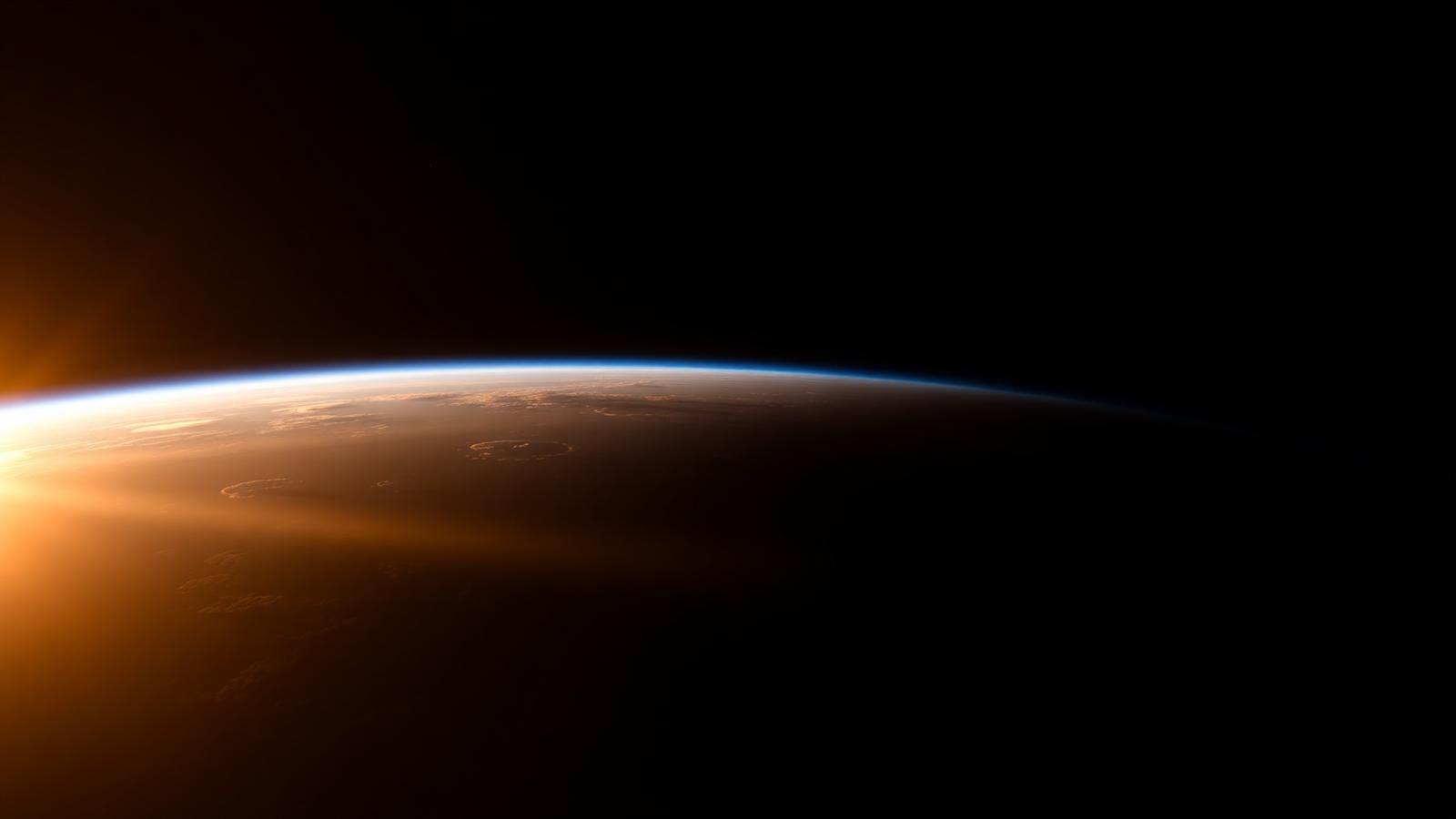 Earth's curved horizon seen from orbit at sunrise