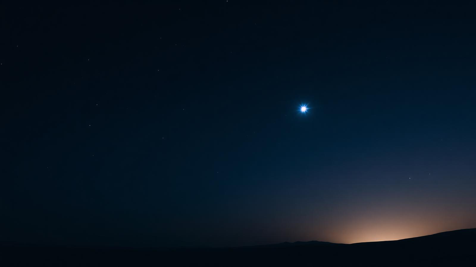 A single brilliant blue-white star above a dark desert horizon